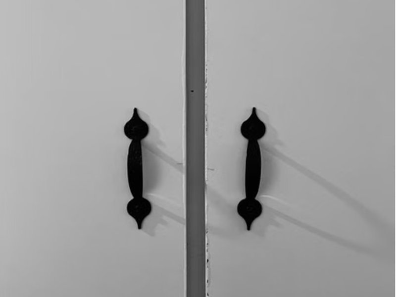Puxadores pretos minimalistas em porta de armário branco