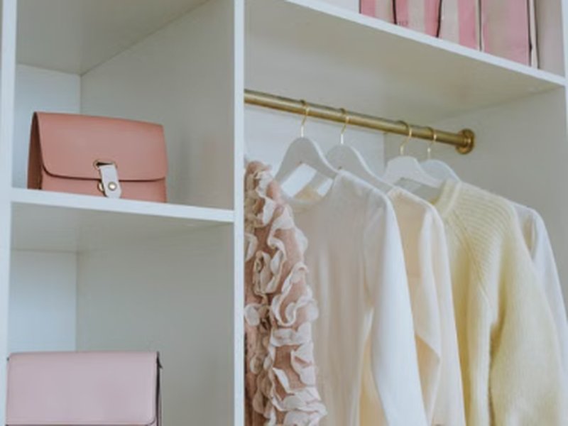 Guarda-roupa pequeno organizado com caixas e cabides bem distribuídos