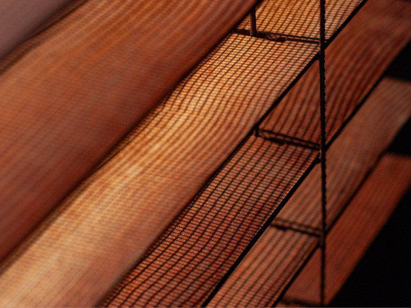 Detalhe da textura de lâminas de uma persiana iluminada pela luz do sol