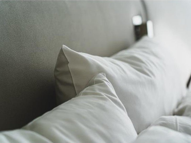 Detalhe da textura macia de um travesseiro branco sobre a cama